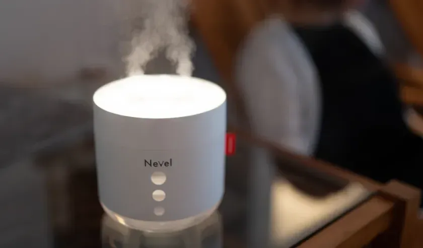 白い円筒形のデバイスが蒸気を放出し、上部が光っています