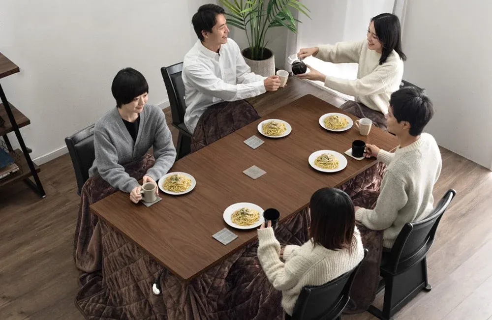 伸長式こたつで食事をする人々