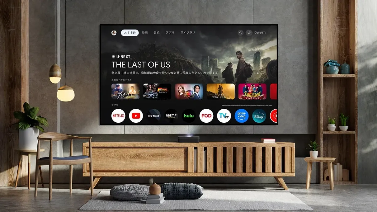 モダンなリビングルームに大画面ディスプレイがあり、Google TVのインターフェースとU-NEXTの「THE LAST OF US」が表示されている