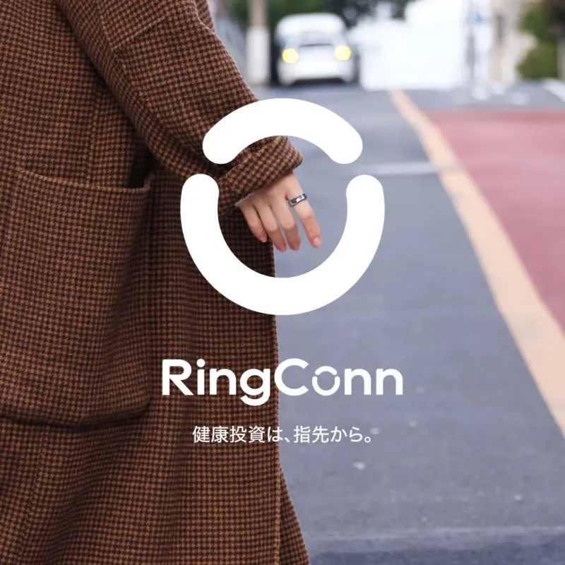 茶色のコートを着た人物がRingConnを着用している画像