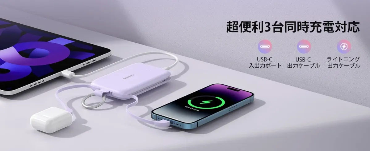 紫色のモバイルバッテリーが、タブレット、スマートフォン、ワイヤレスイヤホンを同時に充電している様子。3台同時充電に対応しており、USB-Cとライトニングケーブルが利用できることを示しています。