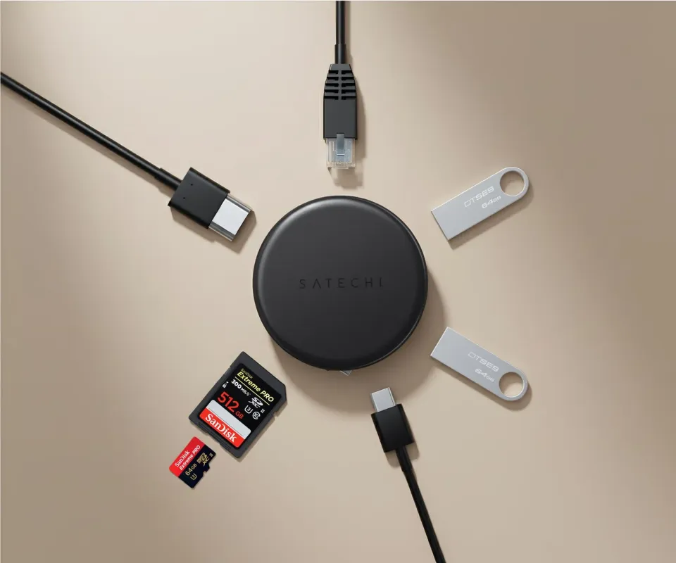 Satechiの黒いデバイスを中心に、USB-Cケーブル、イーサネットケーブル、USBメモリ、SDカードとMicroSDカードが放射状に配置された俯瞰写真