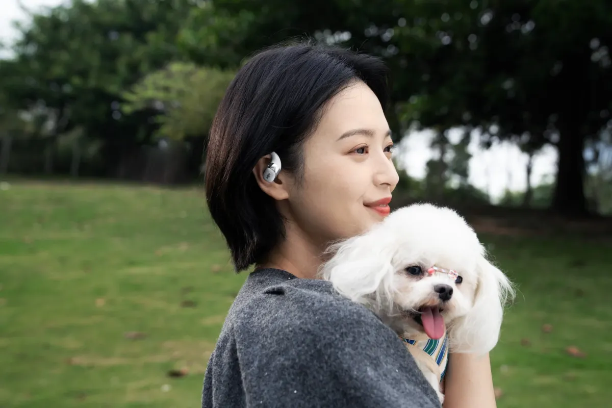 イヤホンを装着して犬を抱く女性