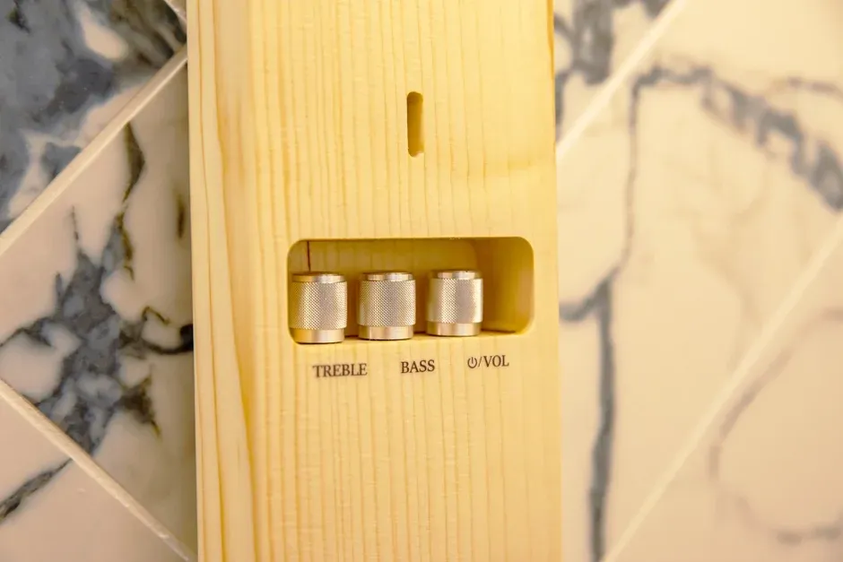 木製のパネルにトレブル、バス、音量調整用の三つの金属製つまみが埋め込まれています