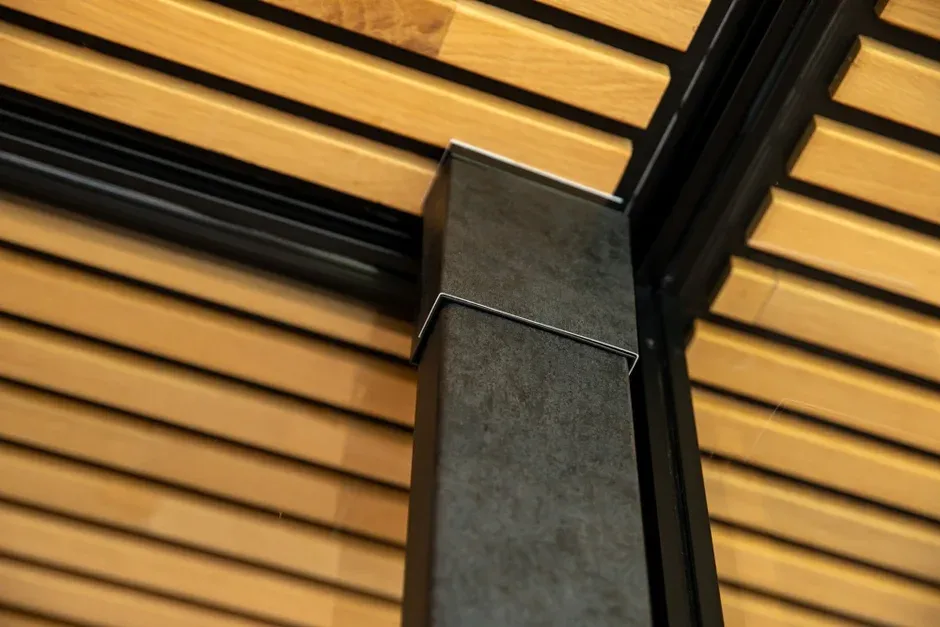 木材のスラットと黒い柱が特徴的なモダンな建築構造