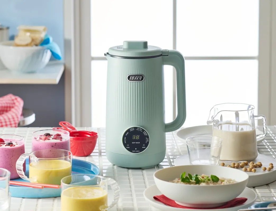 ミントグリーンのToffyスープメーカーと、周りに並べられた豆乳、スムージー、お粥などの料理