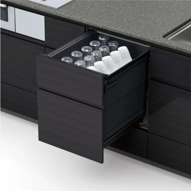 モダンなキッチンの引き出しが開き、透明なグラスと白いコップが整然と並べられています