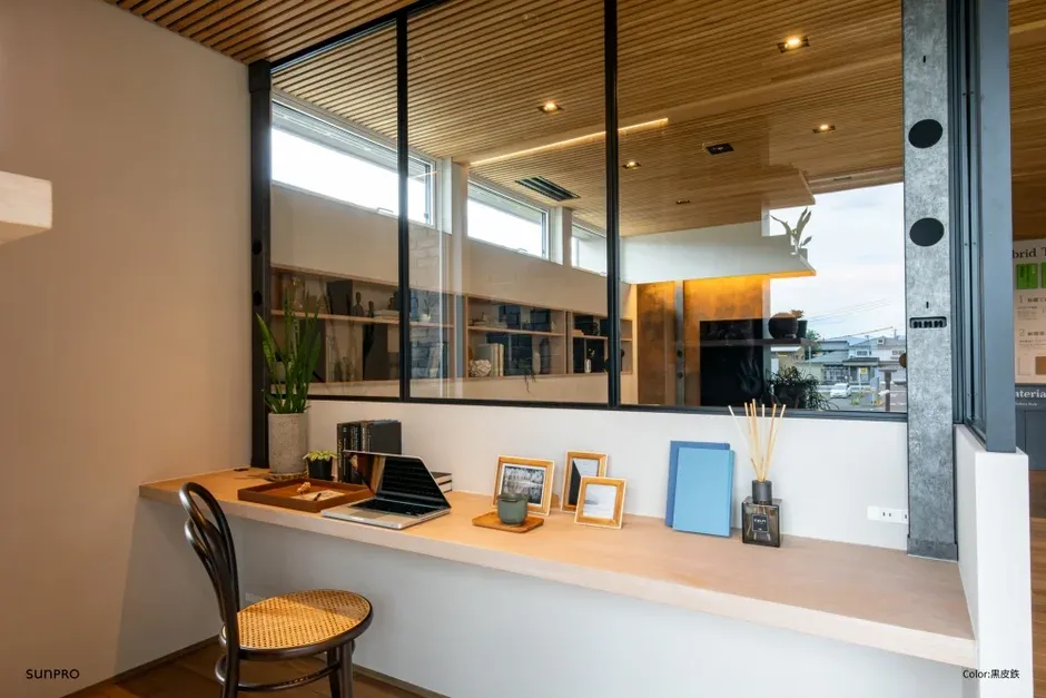 モダンな木目天井の空間に設けられた、窓際のワークスペース