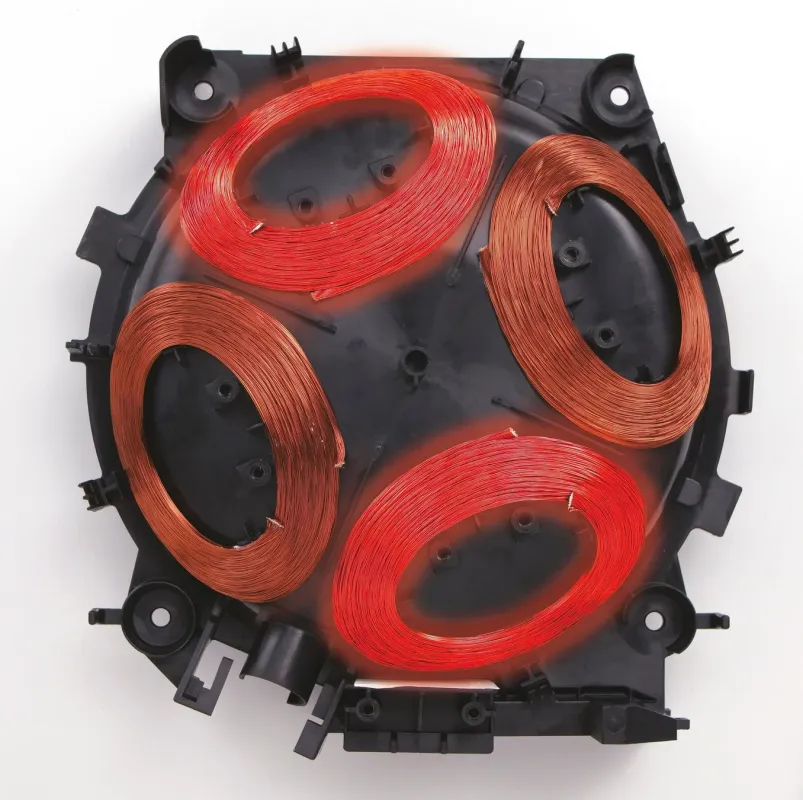 IHクッキングヒーターの内部部品。黒い基盤の上に複数の電磁誘導コイルが配置され、一部は赤く発光している。