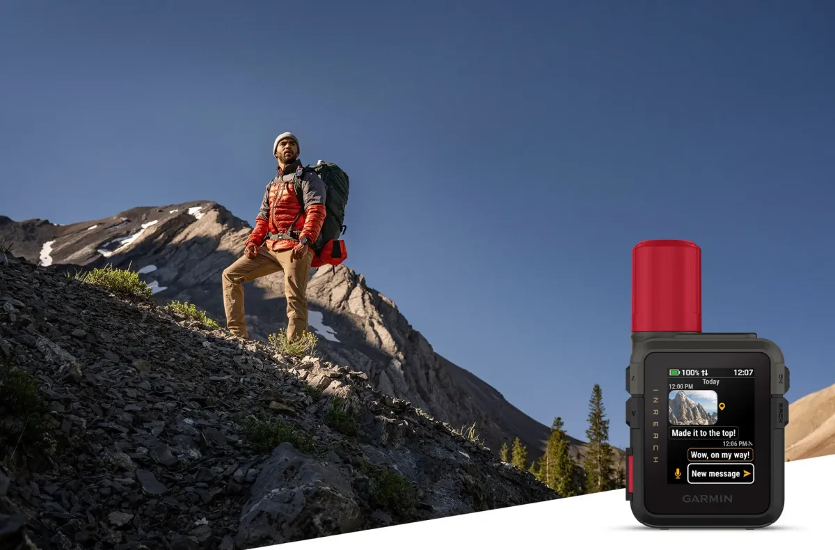 ハイカーが山道を登っており、手前にはGarmin inReachデバイスが置かれている