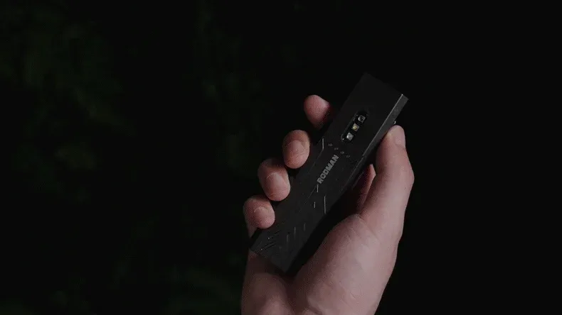 手が黒い電子機器を握っている様子