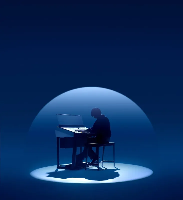 電子キーボードを演奏している人物のシルエット