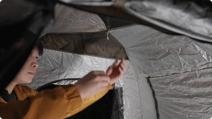 テント内で人物が何かを調整している様子