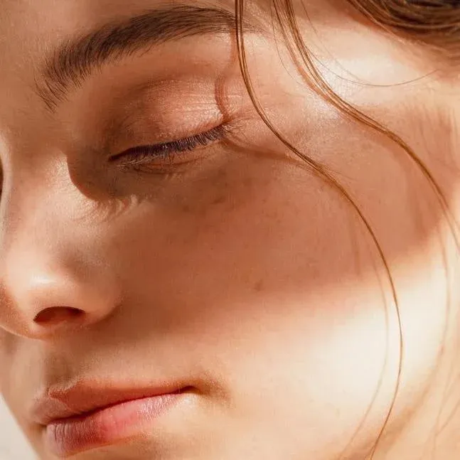 柔らかな自然光が当たる女性の顔のクローズアップ