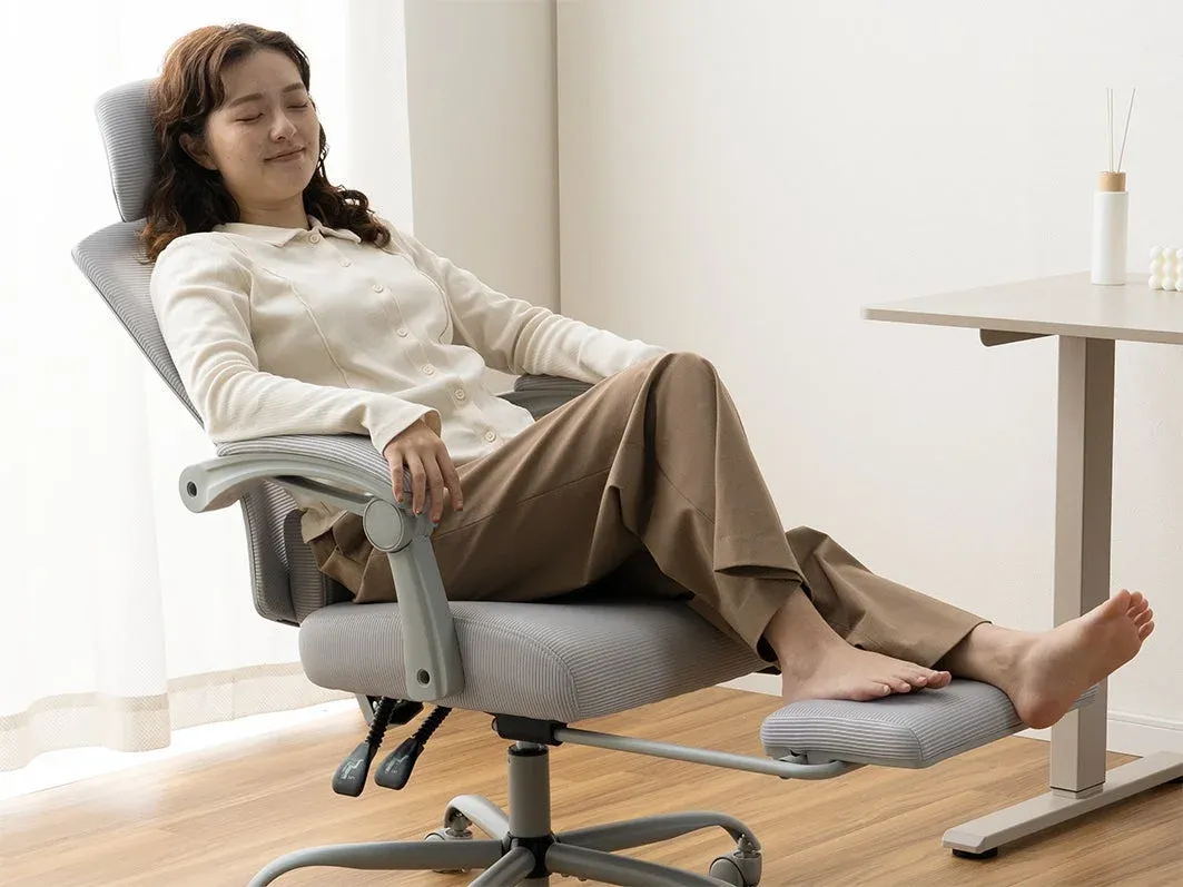 フットレスト付きオフィスチェアでリラックスする女性