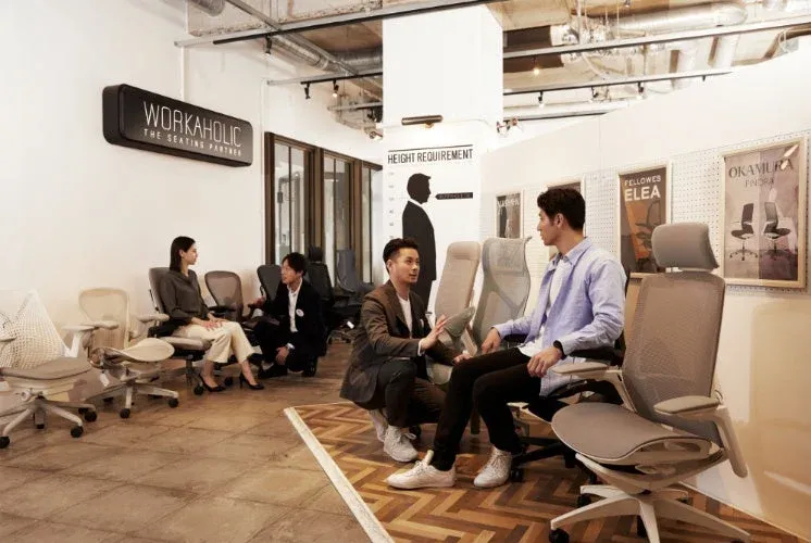 WORKAHOLICのショールームでオフィスチェアを選ぶ人々