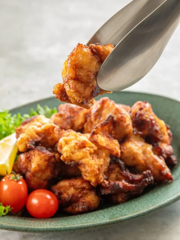 トングで唐揚げを盛り付ける様子