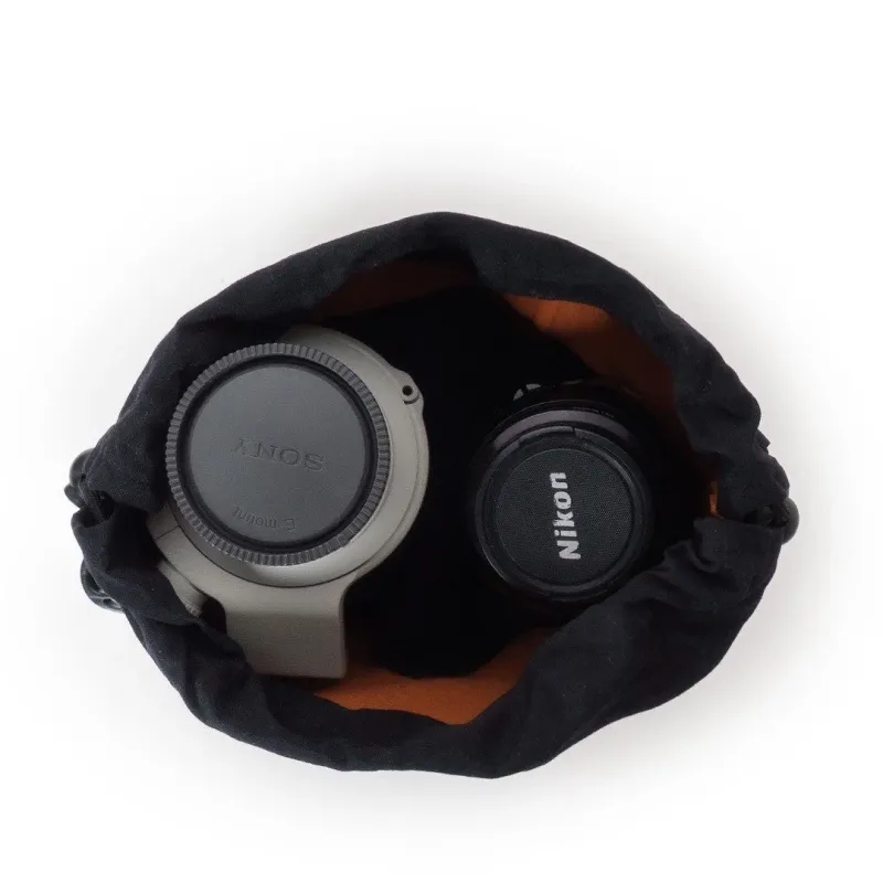 黒い巾着袋の中にソニーEマウントとニコンのレンズまたはアダプターが収納されている様子