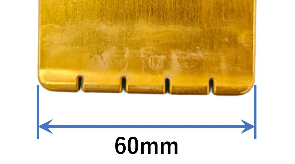 金色の金属部品の拡大画像で、底辺に複数のスリットがあり、全体の幅が60mmと測定値が示されています。