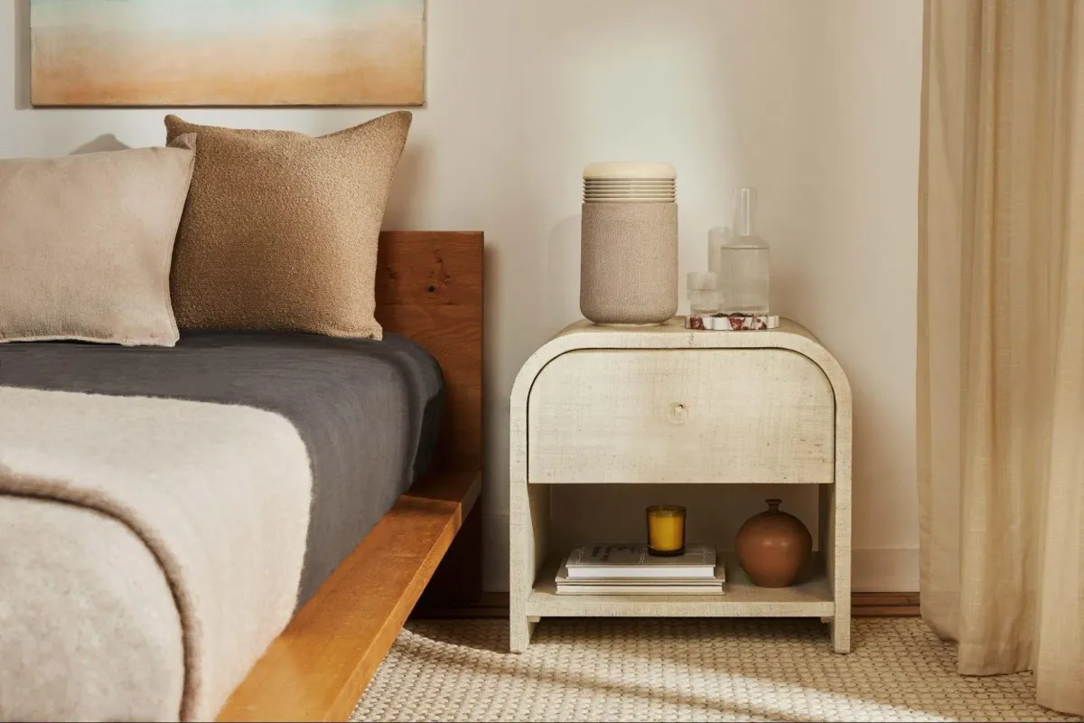 落ち着いた寝室のベッドサイドに置かれた空気清浄機