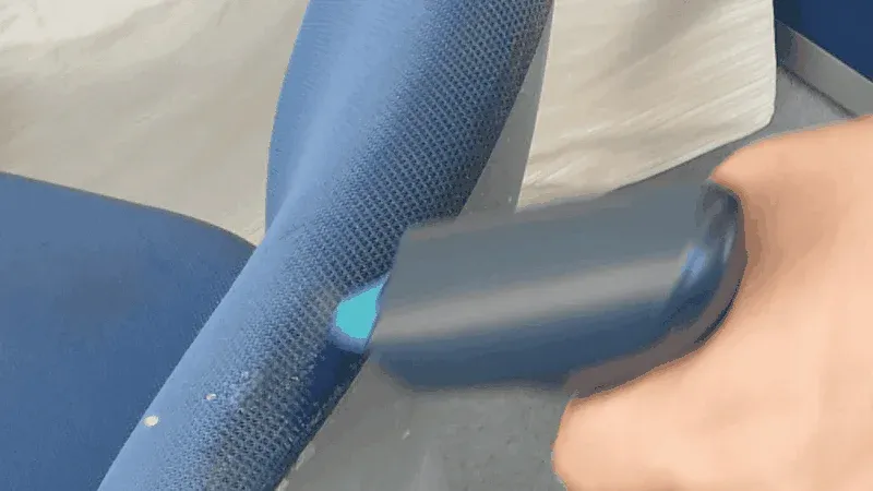 手が青い布地のソファや衣類にデバイスを当て、毛玉を取っている様子です。デバイスからは青い光が発せられています。