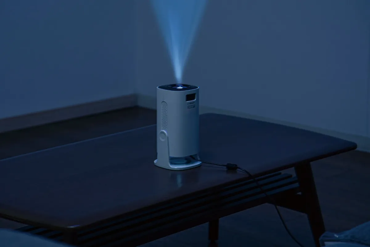 暗い部屋で天井に青い光を投影するプロジェクター