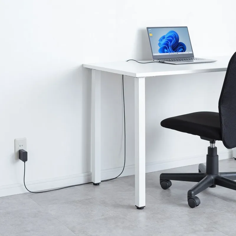 デスクでノートパソコンを充電する様子