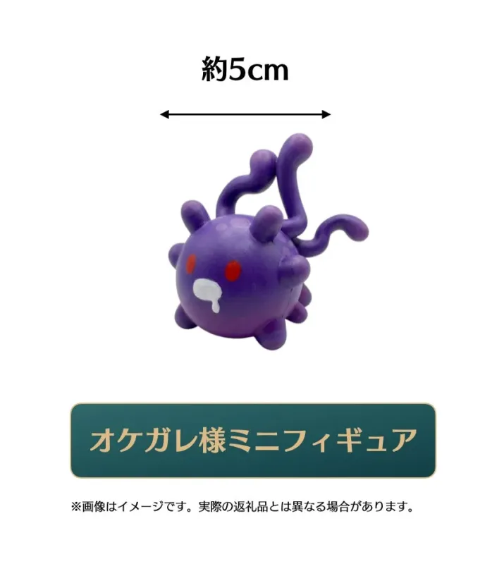 約5cmサイズの紫色のオケガレ様ミニフィギュアが写っています。丸い体に触手のような突起と赤い目、口元に白い模様が特徴です。
