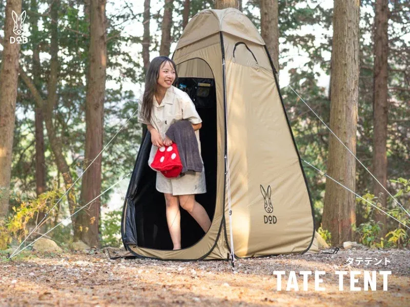 森林の中でテントから出てくる女性