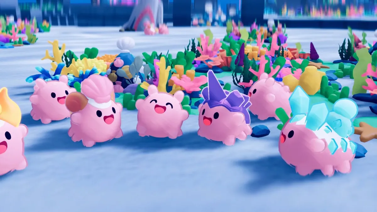 ピンク色の可愛らしいクリーチャーたちが、カラフルなサンゴや植物が生い茂る海底のようなファンタジー世界に集まっています。様々な装飾を身につけたキャラクターたちが笑顔を見せており、ゲームのワンシーンのような楽しげな雰囲気です。