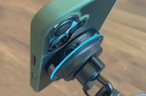 緑色のスマホケースに入ったスマートフォンの背面に、青いLEDが光るマグネット式アクセサリー