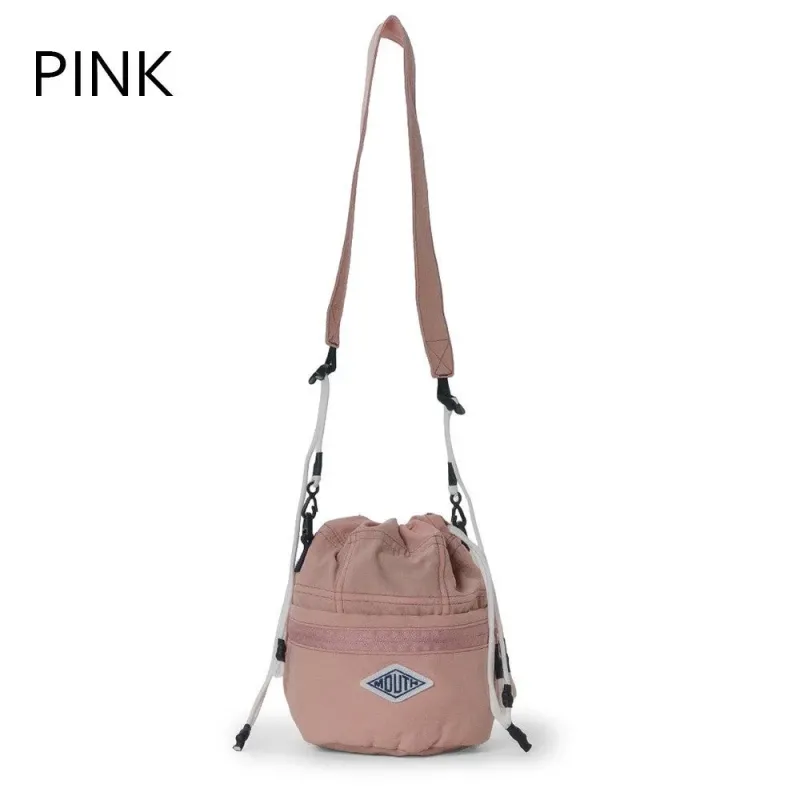 白い背景に吊るされたピンク色の巾着型ショルダーバッグ