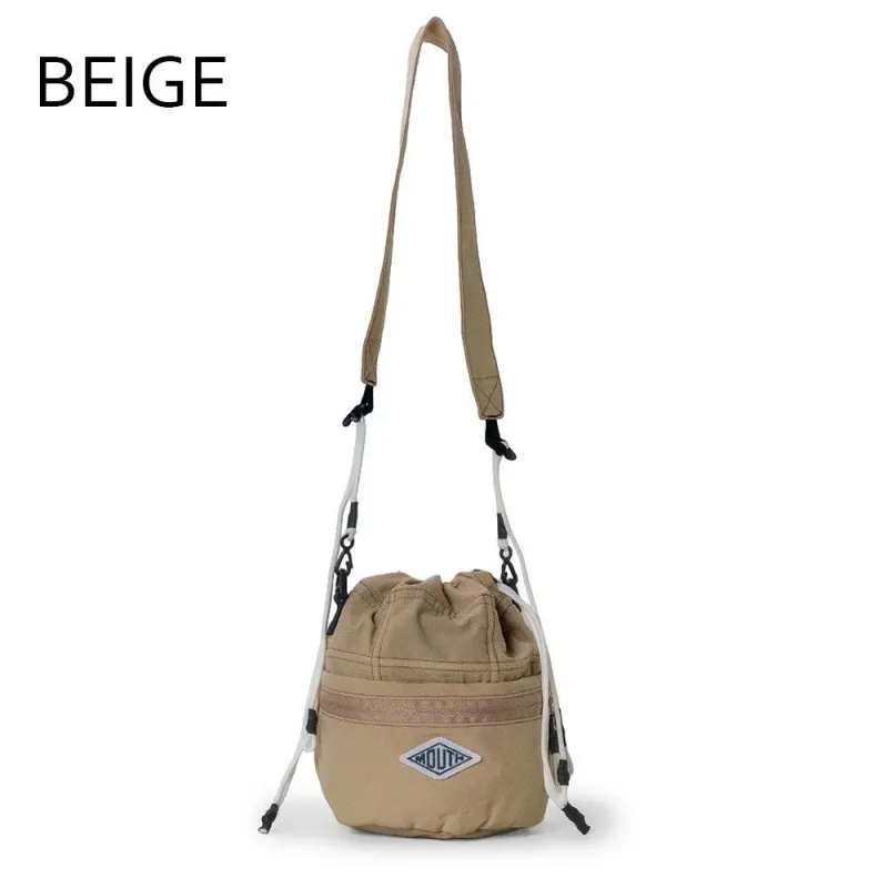 白い背景に置かれたベージュ色の巾着型バケットバッグ