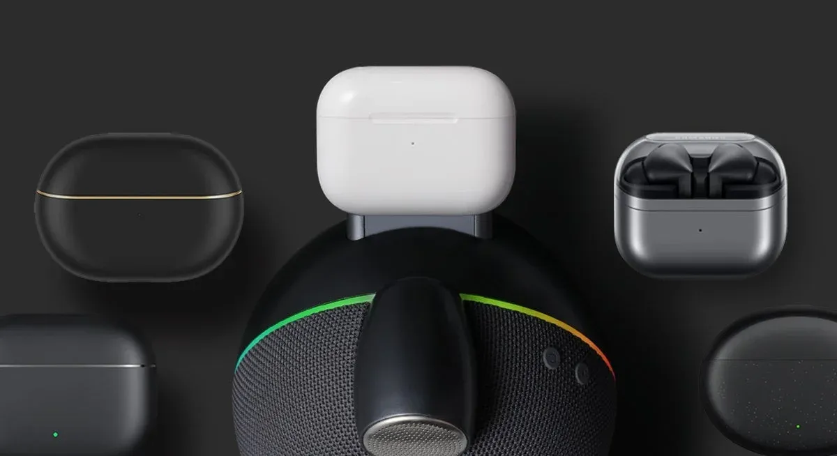様々なブランドのワイヤレスイヤホンケースが、スマートスピーカーのようなデバイスの周囲に配置されています。中央のスピーカーにはカラフルなLEDリングが見えます。