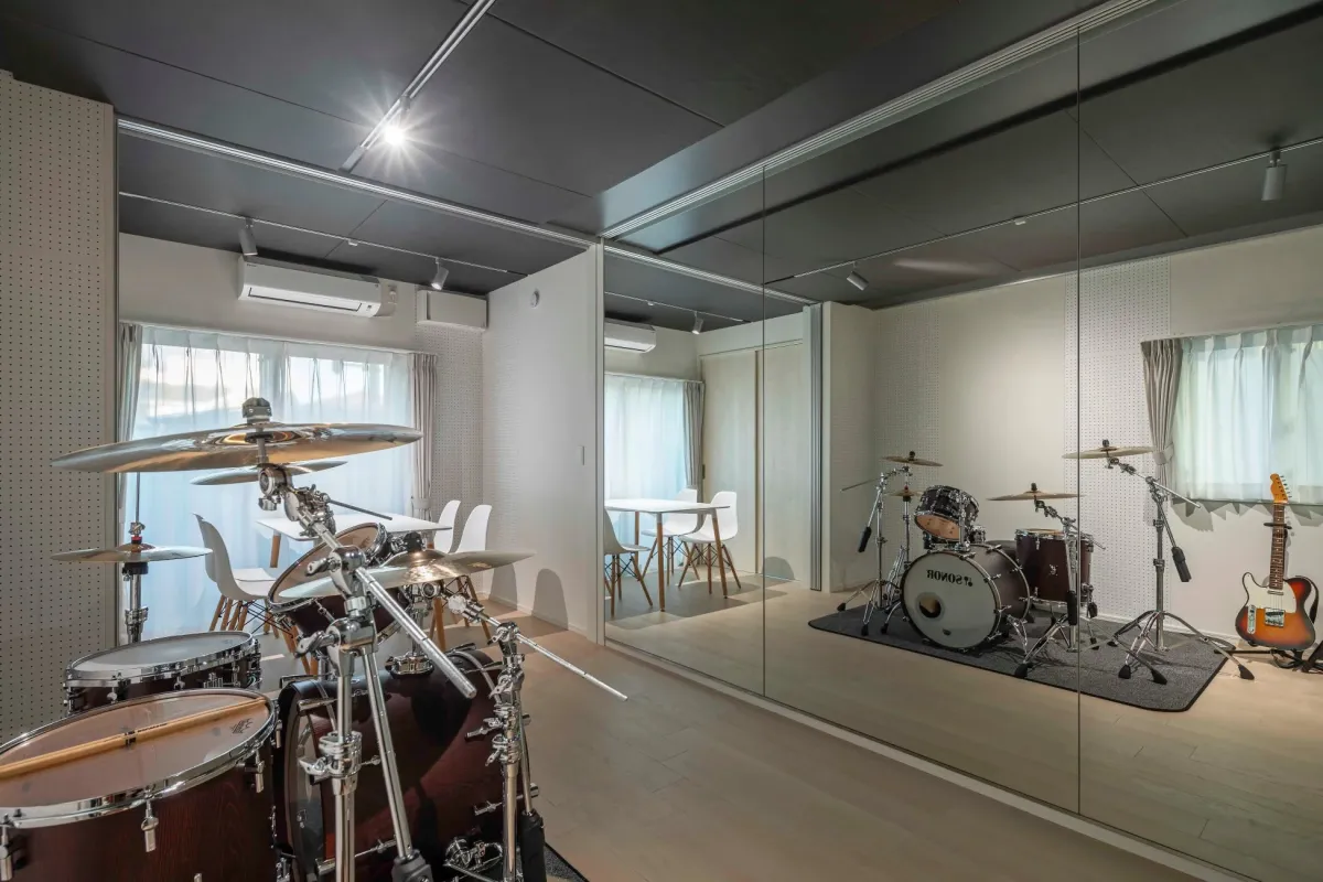 ドラムセットとエレキギターが置かれたモダンな防音室
