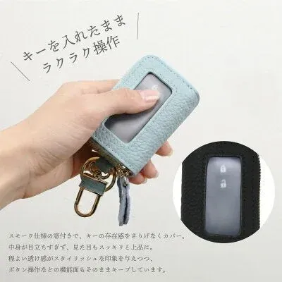 ライトブルーのキーケースを手に持ち、窓付き操作を説明