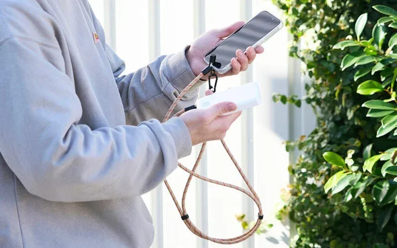 屋外でスマートフォンをモバイルバッテリーで充電する様子