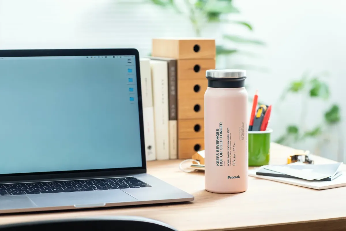 デスク上のピンク色のピーコック製真空断熱ボトル