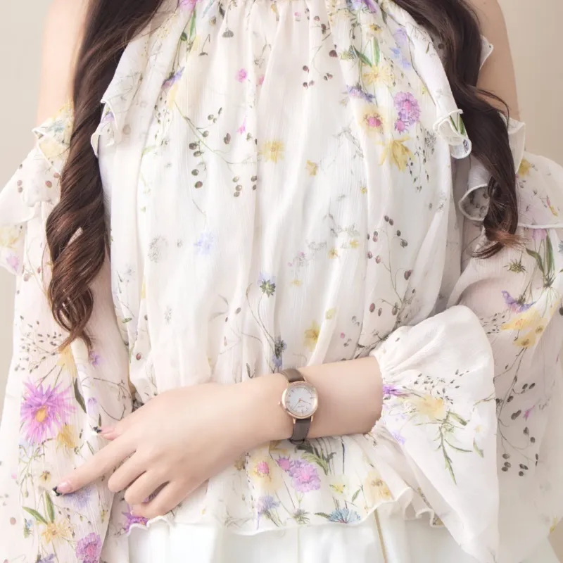 ブラウンのレザーベルトの腕時計を着用した女性