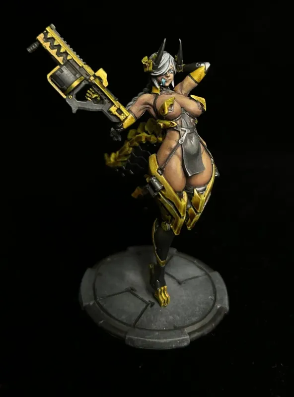 黒い背景に立つ、黄色と黒の装甲を身につけ、大型の銃を持つ女性キャラクターのミニチュアフィギュアです。白い髪と角が特徴的で、セクシーな衣装を着ています。