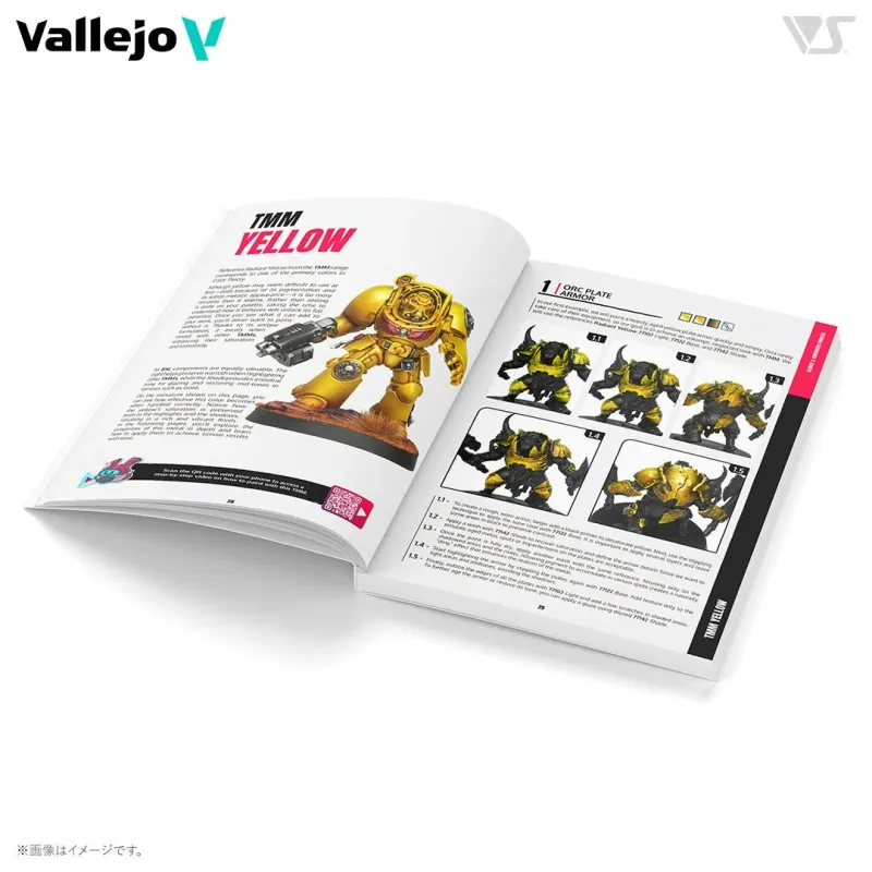 Vallejo社のTMM（True Metallic Metal）塗料のガイドブックが開かれており、「TMM YELLOW」のページでは、リアルな金属表現を可能にするイエロー塗料の特性と塗装方法について説明されています。QRコードで動画チュートリアルへのアクセスも可能です。別のページでは、特定のVallejo TMMイエロー塗料を使用した「ORC PLATE ARMOR」のエイジングされた金属感を表現するステップバイステップの塗装手順が詳細に解説されています。
