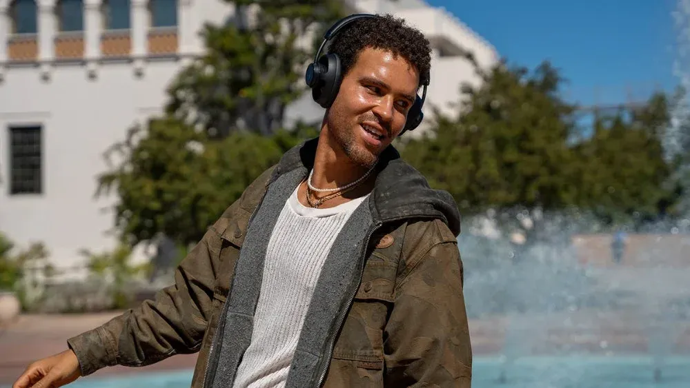 屋外で笑顔の男性がヘッドホンを装着