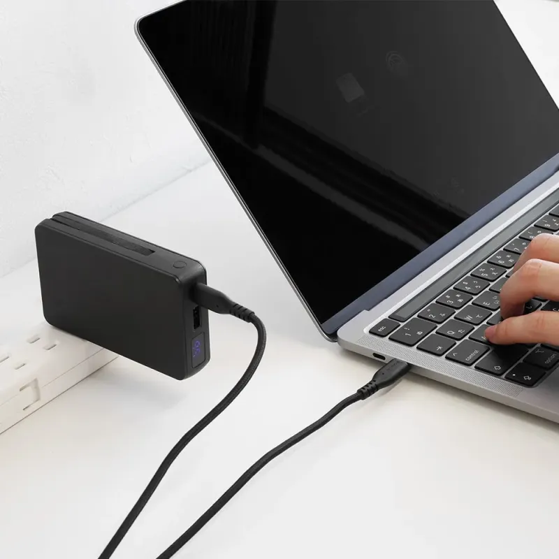 ノートPCを充電中のモバイルバッテリー