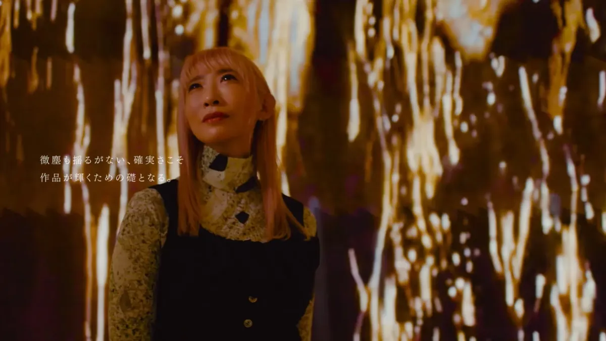 ピンク色の髪の女性が、光の筋が降り注ぐような抽象的な背景の中で、何かを見上げるように立っています。