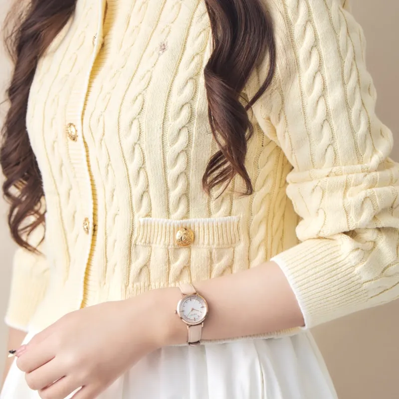 ピンクベージュのレザーベルトの腕時計を着用した女性