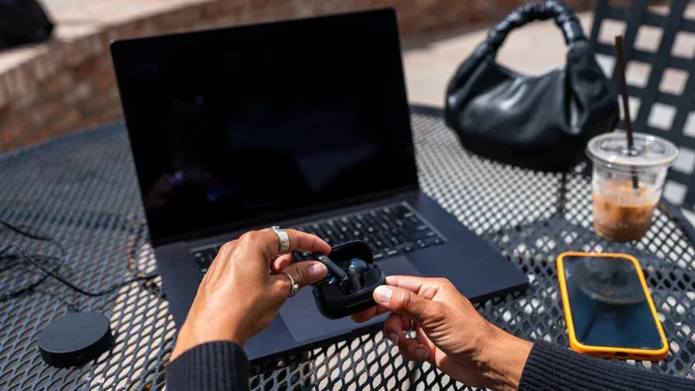 屋外でイヤホンとデバイスを使用する人