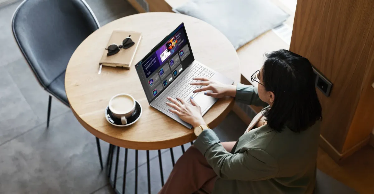 カフェで女性がノートパソコンを使って作業している様子