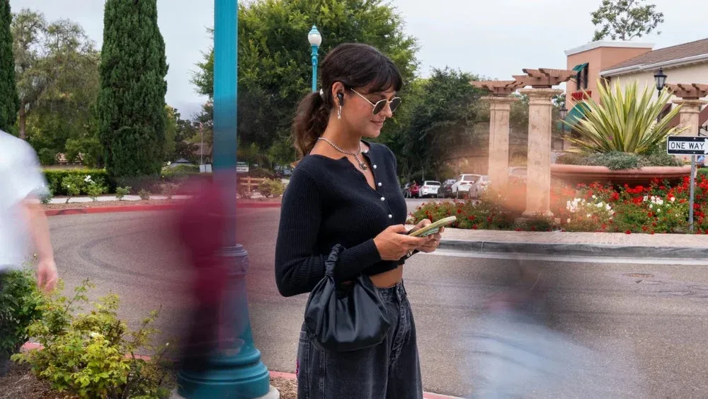 屋外でイヤホンを使用する女性