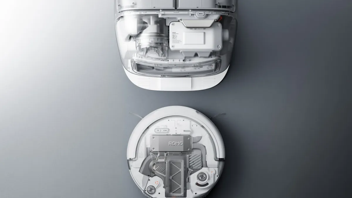 白いロボット掃除機と自動ゴミ収集ステーションの俯瞰図。透明な素材で内部構造が露わになっており、先進的なデザインと技術が強調されています。