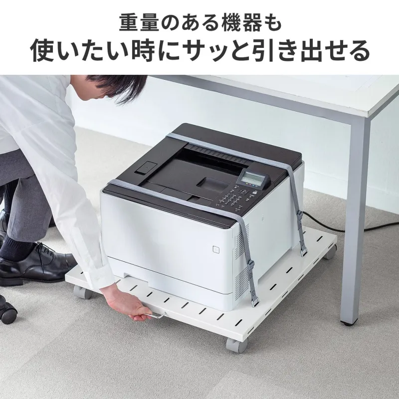 重いプリンターを引き出す様子
